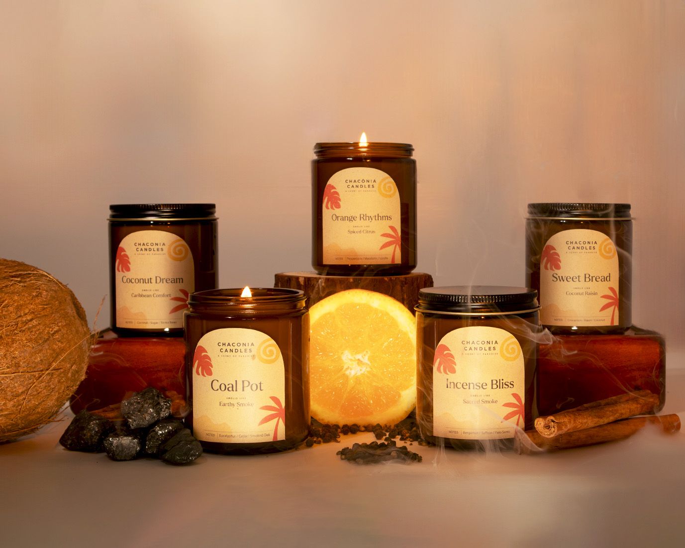 Smoke & Spice full collection group shot with all five candles lit and arranged on wood with coal, orange, cinnamon, and smok